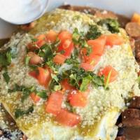 Huevos Rancheros · 2 corn tortillas layered with 2 over-easy eggs, Cotija cheese, cilantro, tomatillo sauce, an...