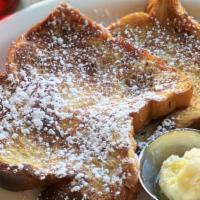 Challah French Toast · Challah French toast dusted with powdered sugar and served with whipped butter and warm syrup.