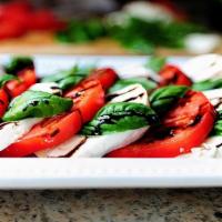Mozzarella Caprese Appetizer · Layered fresh mozzarella, tomato, roasted red peppers, and basil with balsamic glaze.