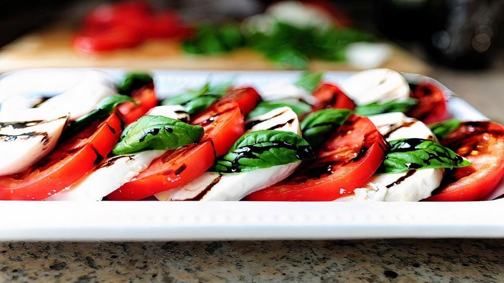 Mozzarella Caprese Appetizer · Layered fresh mozzarella, tomato, roasted red peppers, and basil with balsamic glaze.