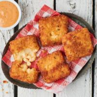 Classic Mac Bites · 4 breaded and fried mac & cheese bites served with a side of Cluck Sauce