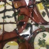 Caprese Salad · Heirloom tomatoes topped with buffalo mozzarella and basil drizzled with EVOO and balsamic v...