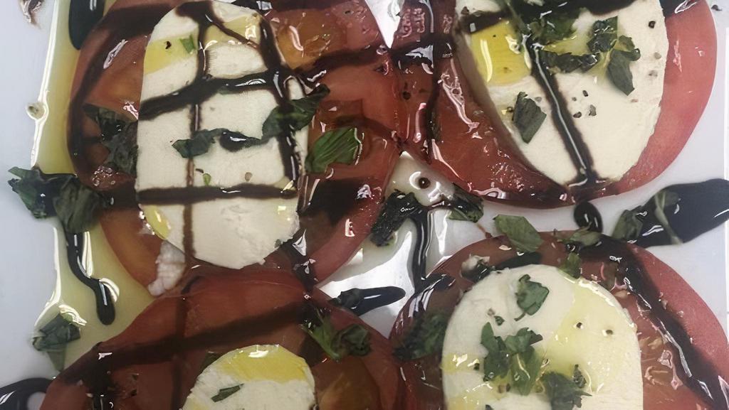 Caprese Salad · Heirloom tomatoes topped with buffalo mozzarella and basil drizzled with EVOO and balsamic vinegar