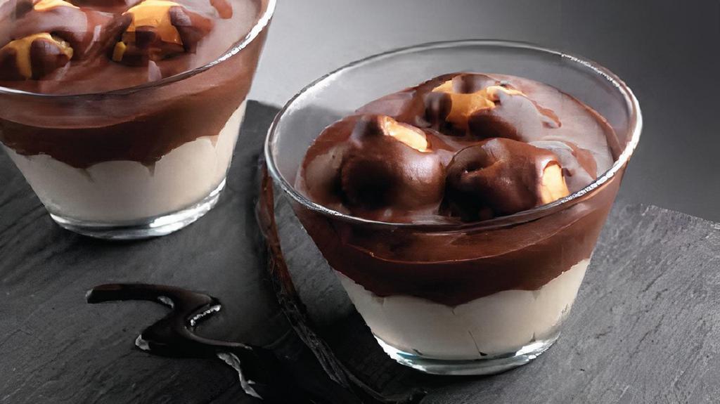 Profiteroles Cup · A layer of vanilla cream topped with cream puffs covered in chocolate.
