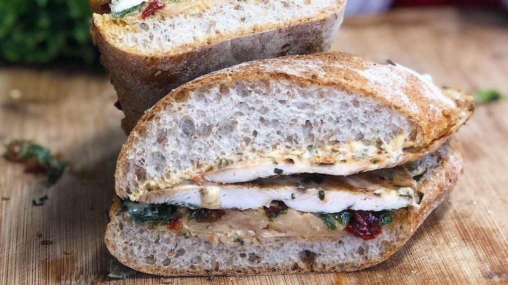 Tuscan Chicken · Grilled lemon chicken, baby kale, marinated fava beans, sun-dried peppers, and sun-dried tomato spread served on a whole wheat ciabatta panini.
