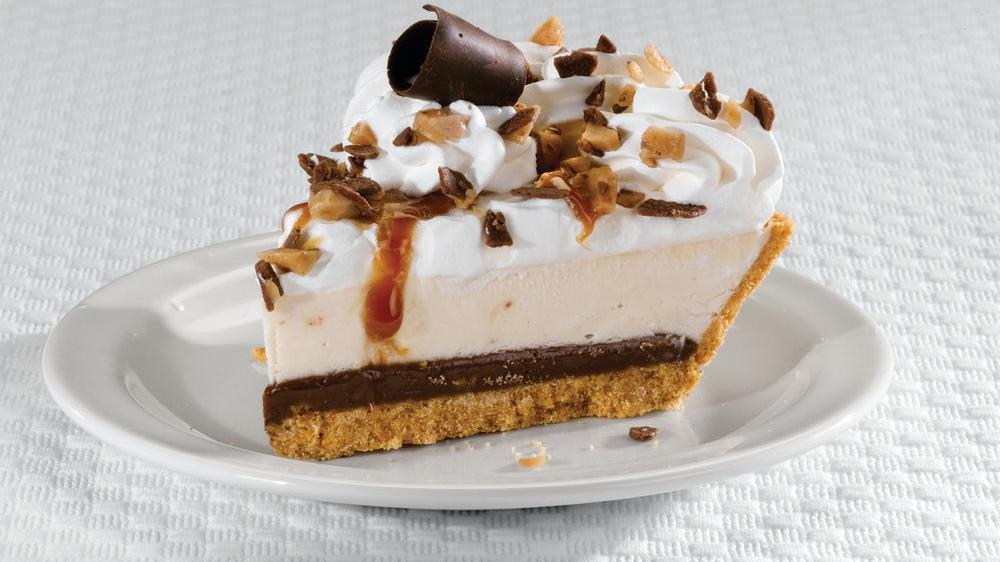 Heath® Crunch Cheesecake Pie · A caramel toffee cheesecake topped with real whipped cream, crushed Heath® bar and chocolate curls, layered with chocolate ganache and toffee pieces in a graham cracker crust. (750 cal/slice).