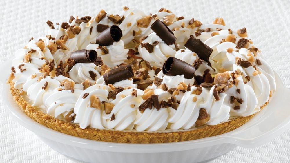 Heath® Crunch Cheesecake Pie · A caramel toffee cheesecake topped with real whipped cream, crushed Heath® bar and chocolate curls, layered with chocolate ganache and toffee pieces in a graham cracker crust. (750 cal/slice)