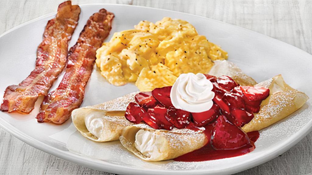 Fresh Strawberry Crepes Platter · Two light delicate crepes filled with sweet vanilla cream cheese, topped with fresh glazed strawberries, powdered sugar and whipped topping. Served with two eggs* and choice of two Applewood smoked bacon strips or two sausage links.