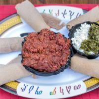 Kitfo · Finely chopped prime lean beef seasoned with herbed butter sauce and spices served with Ethi...