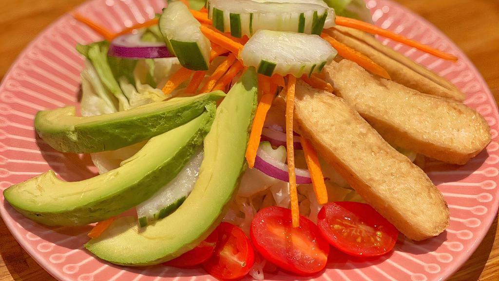 House Salad · Fresh greens, tomatoes, tofu, avocado, carrot served with peanut dressing.