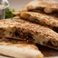 Steak Quesadilla · Hot Quesadilla made with Steak, peppers, onions, mixed mozzarella and cheddar cheese. Includ...