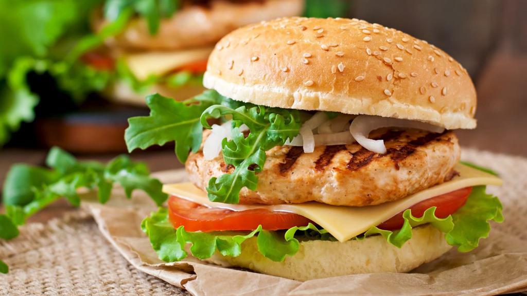 Chicken Sandwich · Chicken cutlet topped with cheese, lettuce, tomatoes on a bun.