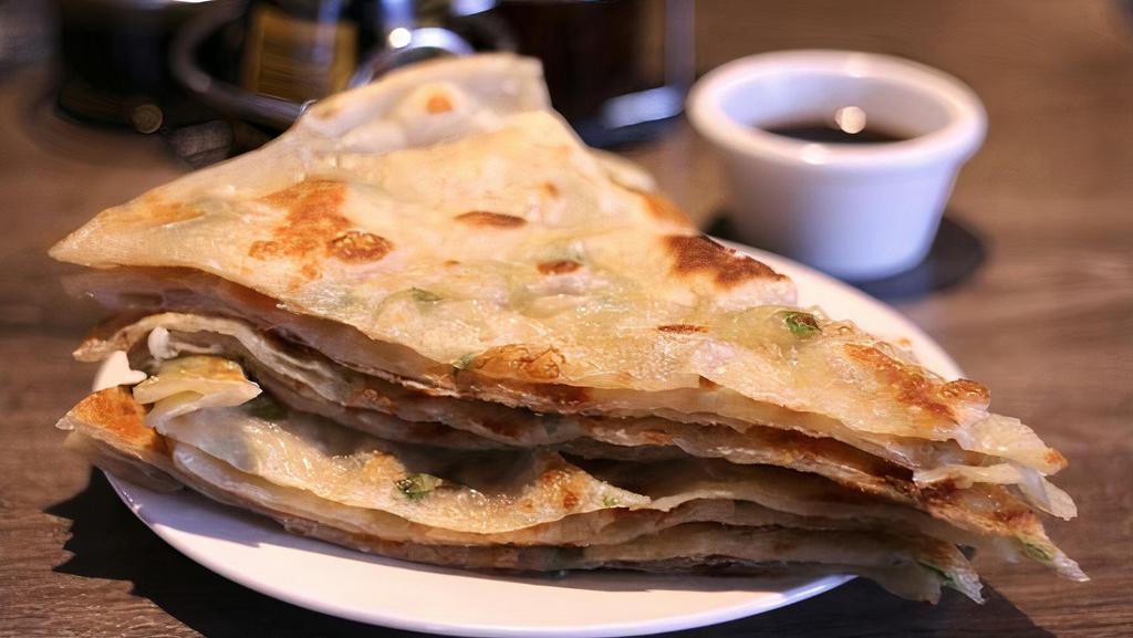 Scallion Pancake · scallion pancake, is a Chinese, savory, unleavened flatbread folded with oil and minced scallions. Unlike Western pancakes, it is made from dough instead of batter. It is pan-fried which gives it crisp edges yet also a chewy texture.