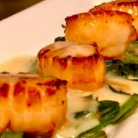 Fresh Seared Sea Scallops · four fresh seared sea scallops on a bed of spinach in a light lemon sauce