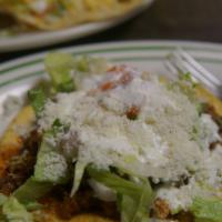 Chorizo Tostada · Mexican sausage. One flat hard shell tortilla with beans, lettuce, tomato, onion, cilantro, ...