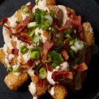 Dirty Tots · Tater tots with cheddar, dirty truffle sauce and bacon crumble