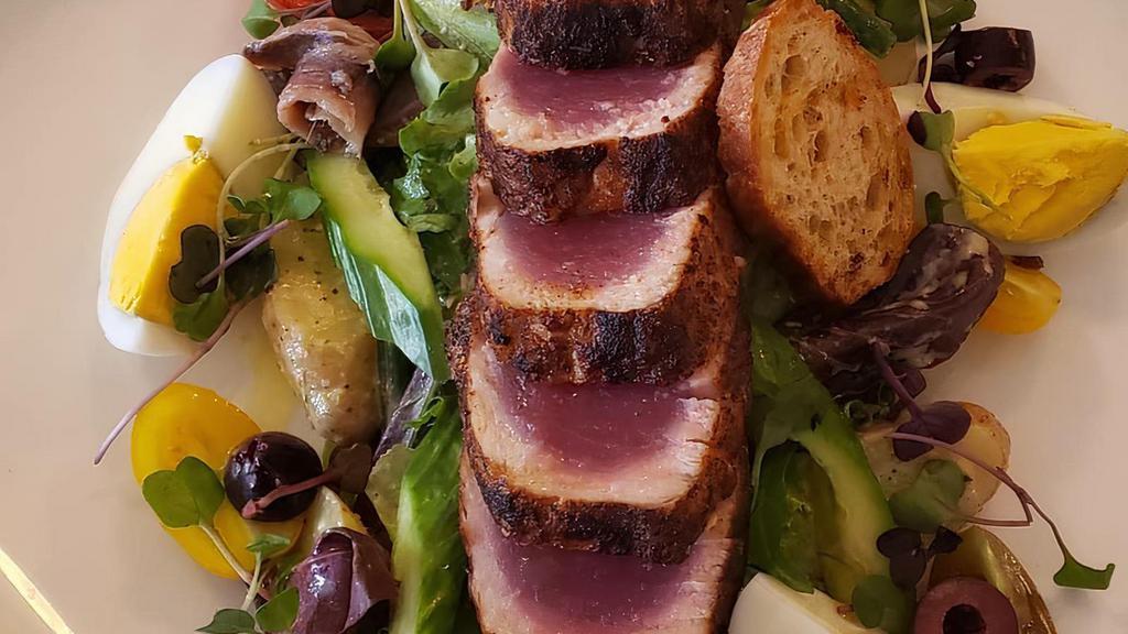 Tuna Nicoise · Seared tuna, egg, black olives, fingerling potato, anchovy, cucumber, French beans, mixed greens, and Dijon vinaigrette.