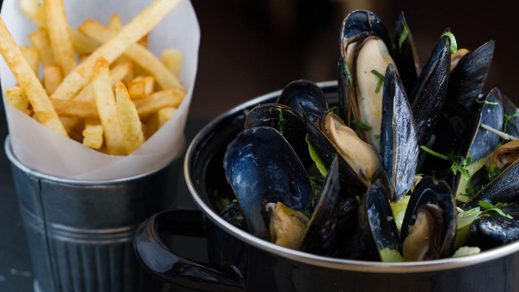Moules Marinières · Traditional steamed mussels in a white wine, butter, and herb broth. Served with pomme frites.