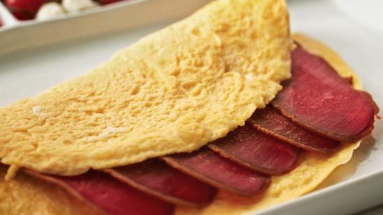 Pastrami Omelette Breakfast · Fluffy pastrami and egg omelette served with toast, home fries, and small tea or coffee.
