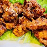 Chicken Kara-Age · Ginger and garlic marinated chicken fried to a golden brown, drizzled with tangy sauce and t...