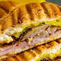 Cubano Sándwich · Braised pork, sliced ham, Swiss cheese, dill pickle, garlic aioli, in a roll.