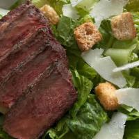 Steak Caesar Salad · Steak served on a bed of Romaine lettuce, shaved pecorino romano, herbed croutons, with a si...