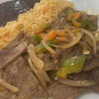 Bistec A La Mexicana · Steak sautéed with onions, tomato and jalapeno. Served with rice and beans.