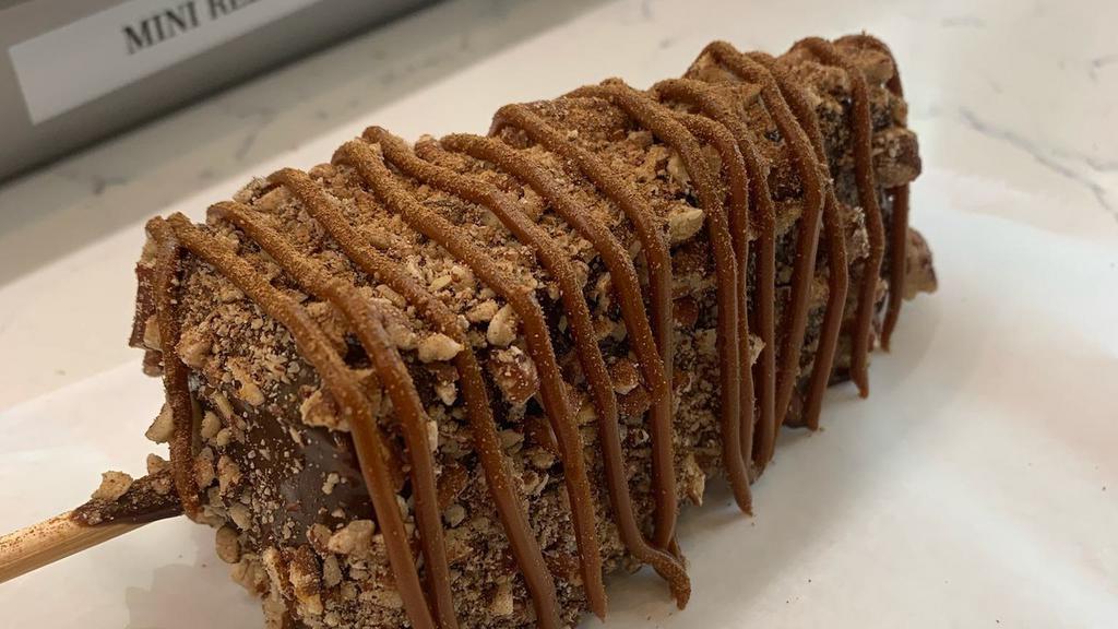 Pecan Pie Cheesecake · New York cheesecake dipped in Ghirardelli milk chocolate rolled in toasted pecan drizzled with caramel salted e age sprinkled with cinnamon.