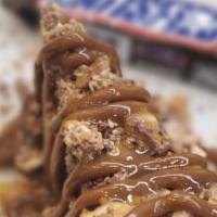 Snickers Bar Cheesecake · New York cheesecake dipped in Ghirardelli milk chocolate Covered with snickers bites then dr...