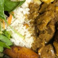 Curry Goat Dinner · Curried Goat served with choice of rice, veggies, and a piece of plantain.