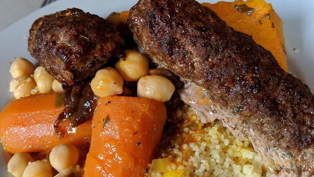 Couscous With Two Kofta Kebob · Steamed semolina grain served with kofta kebob, vegetable bouillon with carrots, sweet potato, zucchini, cabbage, caramelized onion and raisin.