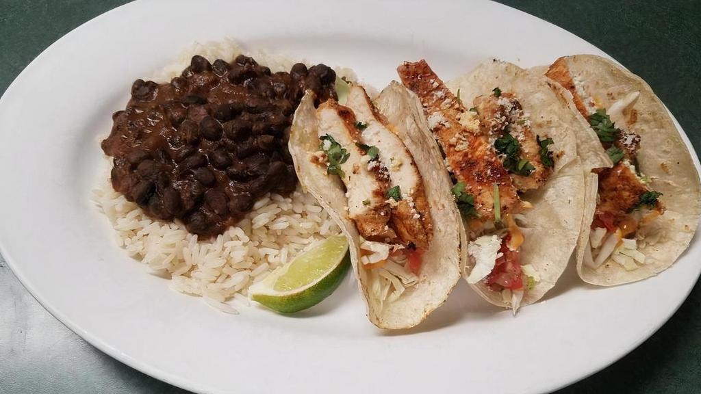 *Street Tacos · grilled cajun-spiced chicken, shredded cabbage, pico de gallo, spicy aioli, cotija cheese, cilantro, lime, black beans & rice, choice of flour or corn tortillas