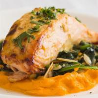 Grilled Salmon · Served over a bed of carrot puree and sautéed spinach.