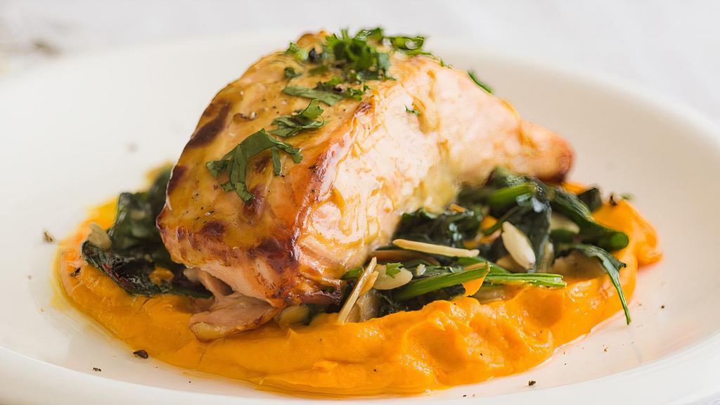 Grilled Salmon · Served over a bed of carrot puree and sautéed spinach.