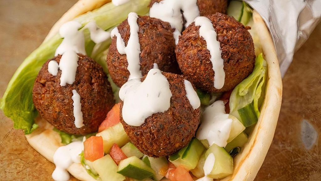 Falafel Gyro · Served on a warm pita with Falafel and topped with shredded lettuce, our chopped Greek Salad. (Red onions, cucumbers, peppers and tomatoes. Finished off with famous White Sauce.