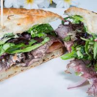 Con Amor Steak Sandwich · Marinated sliced steak with roasted garlic, lettuce, red onion and chipotle mayo. Served on ...