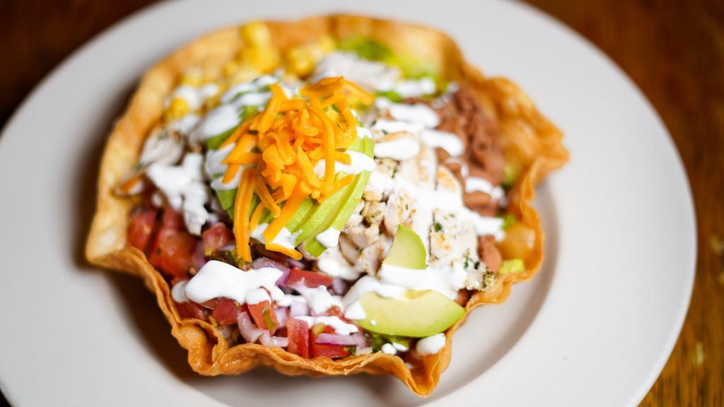 Taco Salad · Romaine lettuce, tomato and corn salsa, guacamole, sour cream, beans, and mozzarella cheese, and choice of meat in a crispy tortilla bowl.