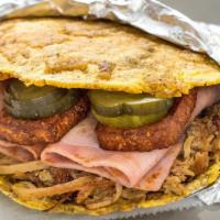 Cubano Patacon · Pulled roasted pork, ham, fried queso, sliced sour pickles, and salsa Verde.