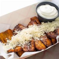 Sweet Plantains With Queso · Fried yellow sweet plantains with queso and nata (housemade sour cream).