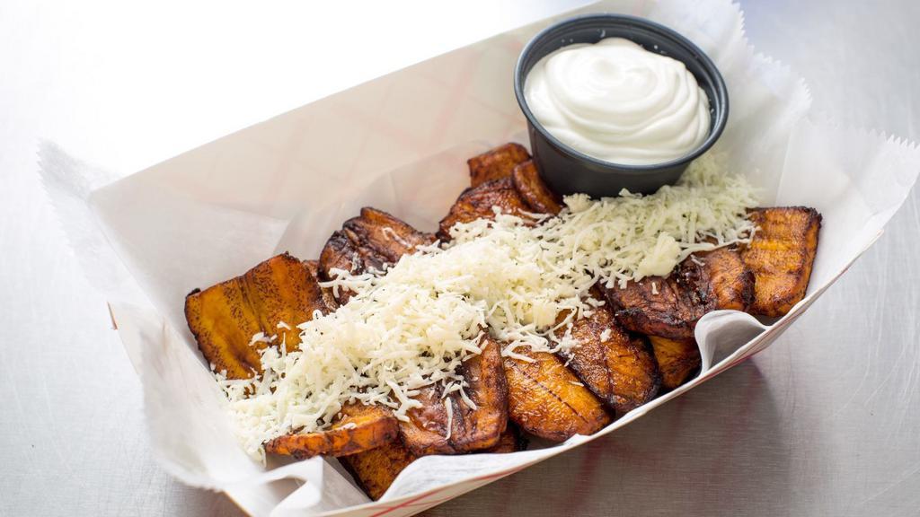 Sweet Plantains With Queso · Fried yellow sweet plantains with queso and nata (housemade sour cream).