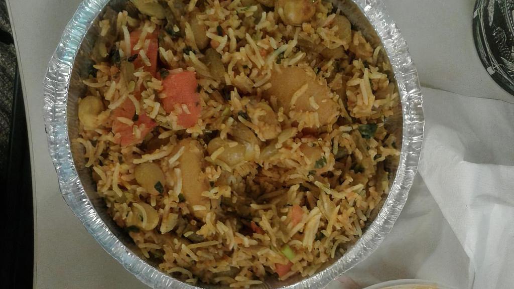 Vegetable Biryani (Vegan) · Saffron flavored basmati rice cooked with fresh vegetables and Indian spices. Served with raita.