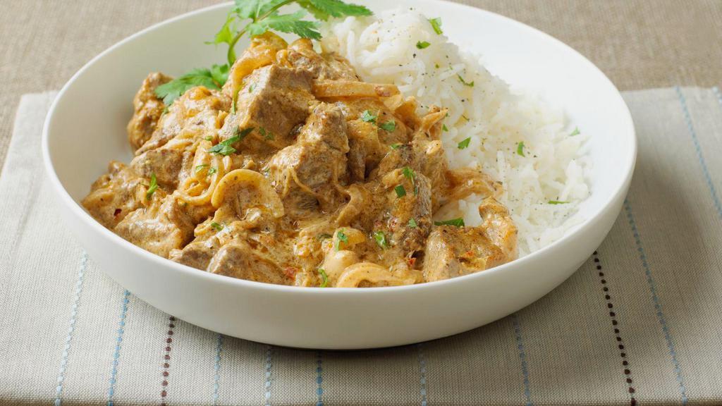 Goat Korma · Tender goat simmered in rich creamy cashew sauce. Served with a side of basmati rice.