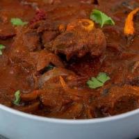 Goat Vindaloo · Tender goat cooked with tangy spicy tomato sauce and potatoes. Served with a side of basmati...