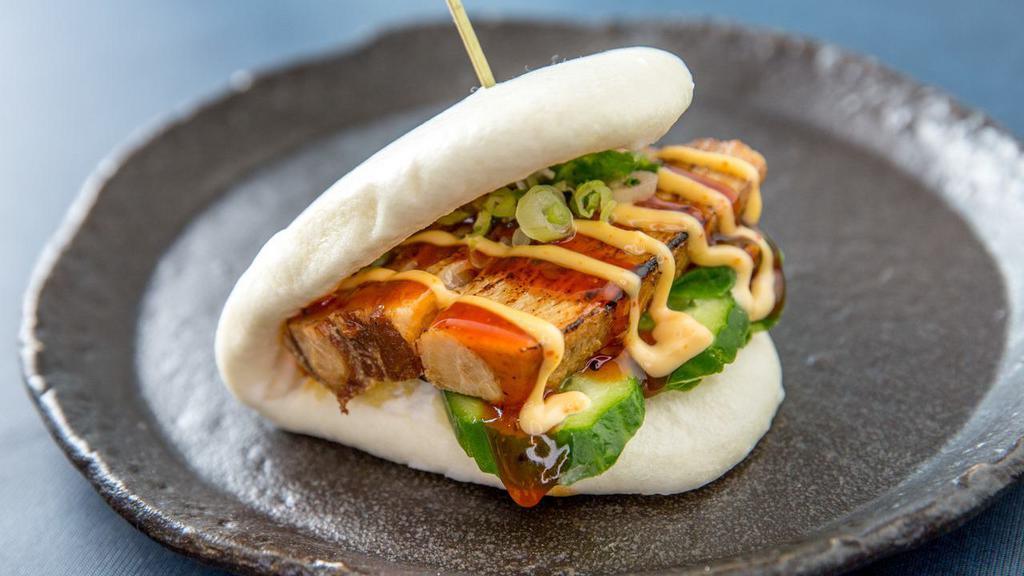 Kakuni Bun · Braised pork with mixed greens, cucumber, scallions, and spicy mayo BBQ sauce in a steamed bun.