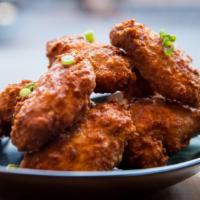 Chicken Wings · Crispy chicken wings with signature red chili sauce.