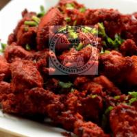 Chicken 65 · Boneless chicken fried and tossed with green chilies, curry leaves, and spices.