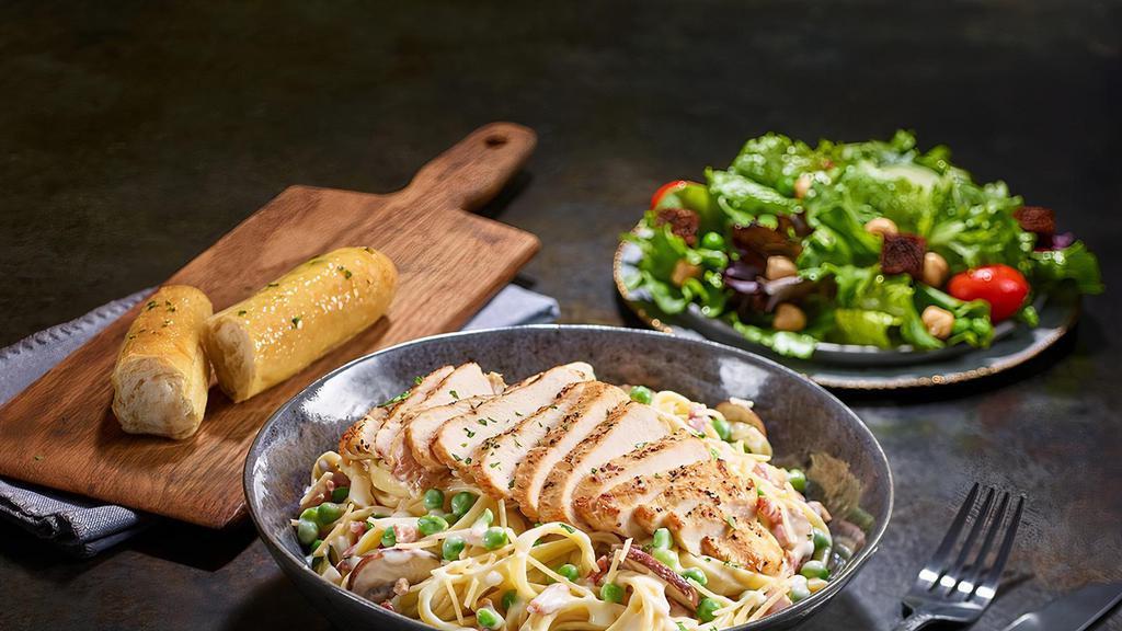 Chicken Carbonara · Grilled chicken served atop fettuccine tossed with alfredo sauce, bacon, peas, roasted baby bellas, and Parmesan cheese.  Served with 4 Breadsticks.