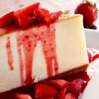 New York Cheesecake · Thick, rich, and creamy. Topped with a generous blanket of juicy strawberries.
