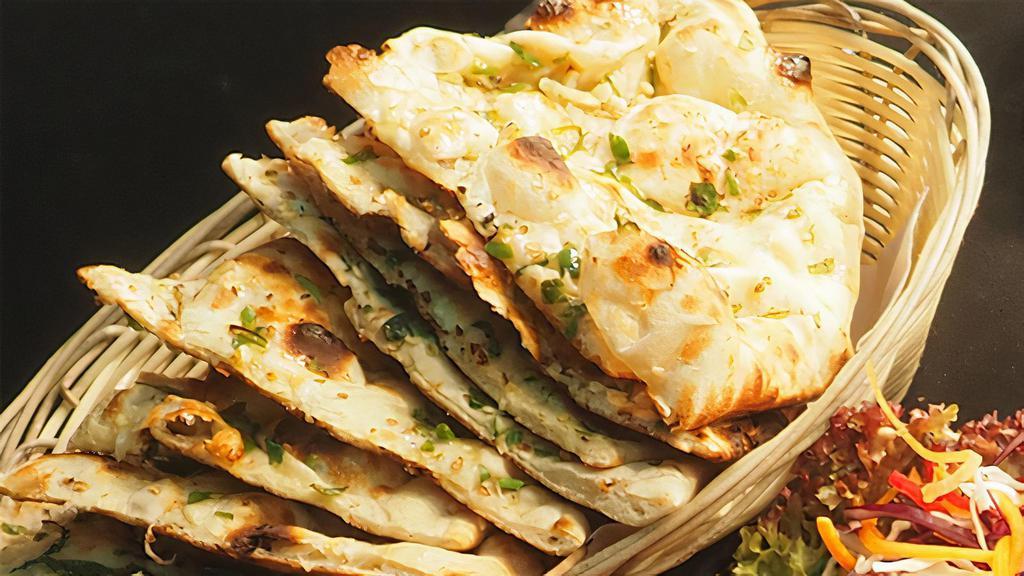 Garlic Naan · India's famous white bread baked in fresh garlic in clay oven pot (tandoor).