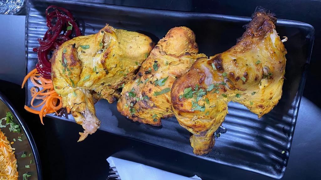 Tandoori Chicken · Tender pieces of chicken on the bone marinated with spices and a ginger garlic paste.